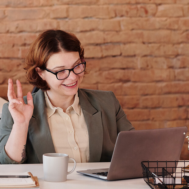 Female elementary school teacher enjoying a cup of coffee whilst meeting with her mentor online.